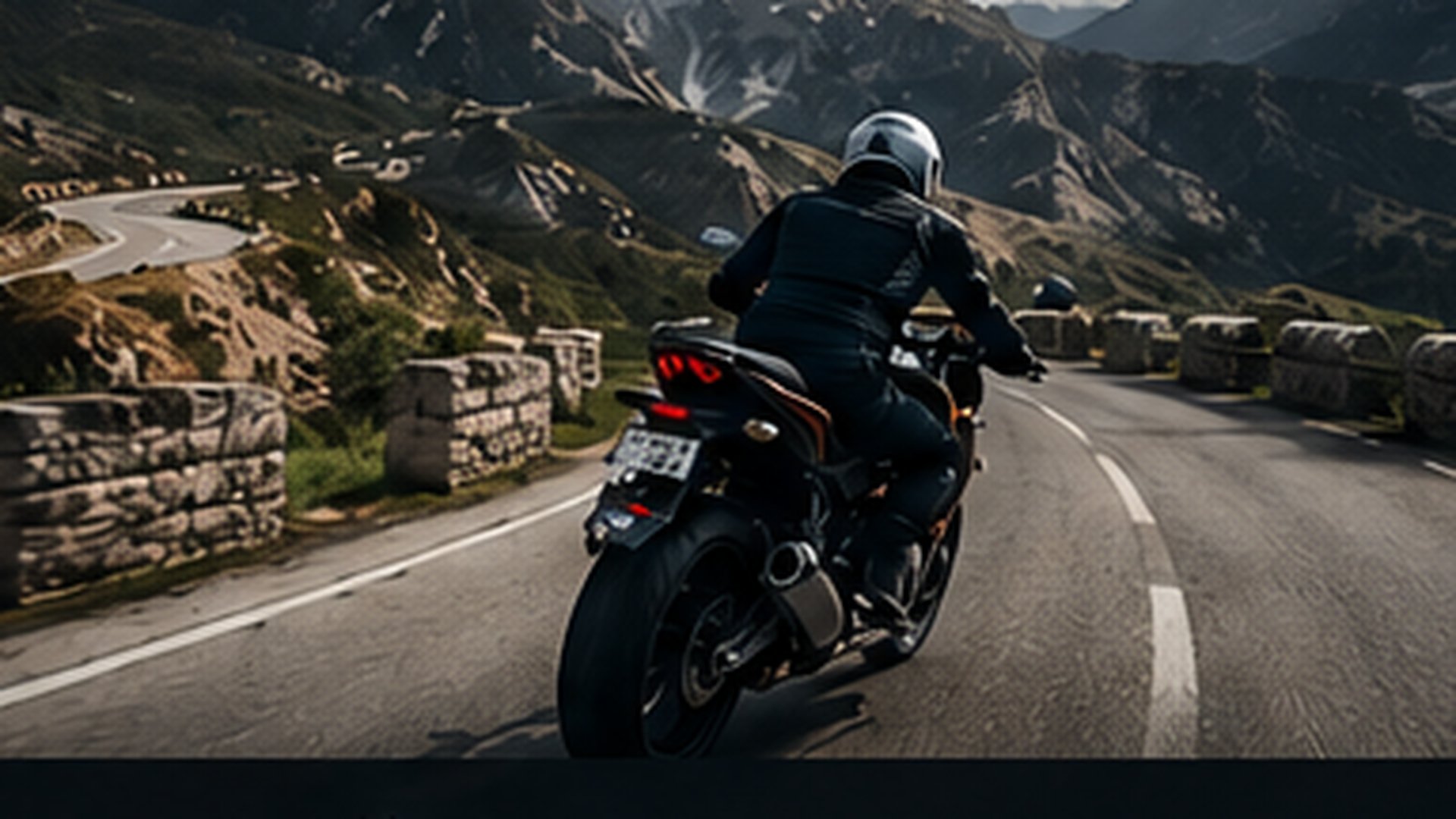 Motard de dos en équipement complet (casque + blouson + gants) en mouvement sur une route de col de montagne — illustration de la protection des mains à moto